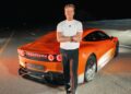 A man in a white shirt stands with arms crossed in front of a Mercedes-AMG GT on a deserted road at night, evoking the thrill of chasing the 24-Hour Distance World Record at Nardò.