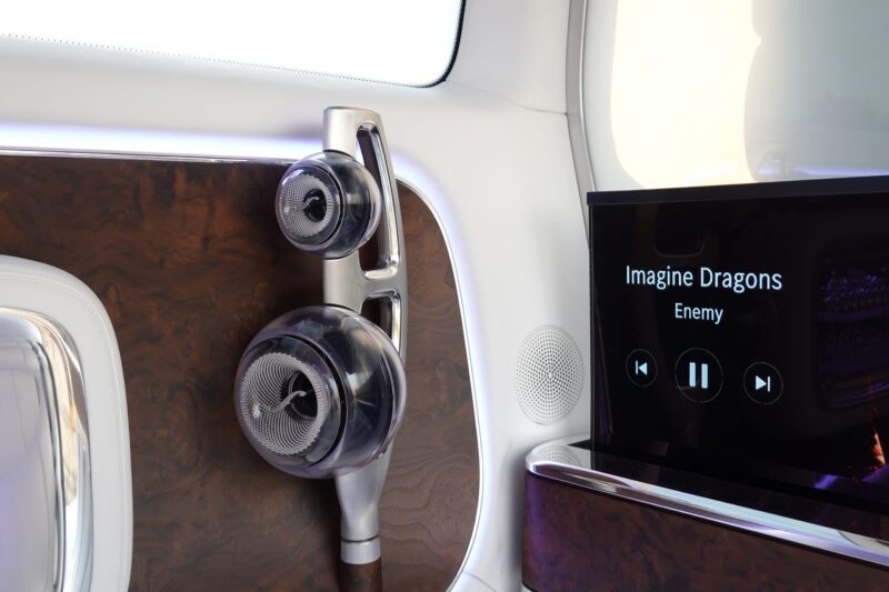 Close-up of a Mercedes-Benz Vision V concept van luxury audio system, with speakers and a screen displaying "Enemy" by Imagine Dragons on pause.