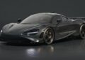 A matte black McLaren 765LT sports car, reminiscent of the 750S Le Mans, is parked indoors on a reflective surface, viewed from the front left angle.