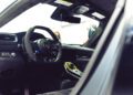 Interior view of a luxury Maserati GT2 Stradale sports car featuring a black leather steering wheel, modern dashboard, and advanced console controls—ideal for showcasing at Car Week.
