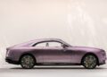 A side view of a luxury two-door coupe car in metallic pink with chrome and gold detailing, set against a neutral background, inspired by Rolls-Royce Motor Cars’ Bespoke Spectre collection.