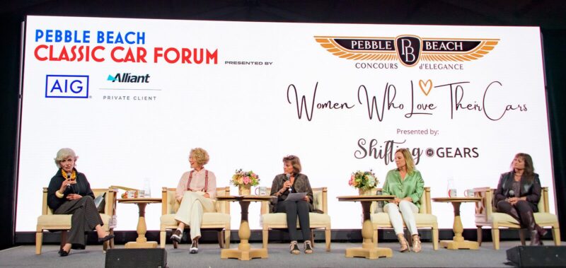 Five women sit on stage engaged in a panel discussion at the Pebble Beach Classic Car Forum during Monterey Car Week 2025, with duPont REGISTRY event branding displayed on a large screen behind them.
