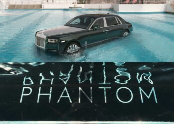 A Rolls-Royce Phantom is partially submerged in a swimming pool, its iconic "PHANTOM" lettering shimmering like music notes beneath the water's surface.