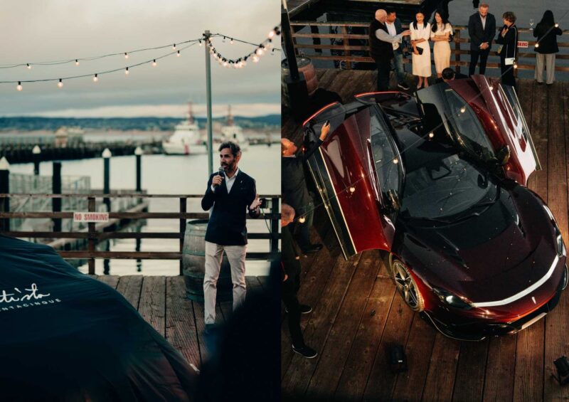 A man speaks at an outdoor event near the water, while nearby a group gathers around a red Automobili Pininfarina Battista Novantacinque on a wooden deck—marking the closing chapter for this one-off at Pebble Beach.