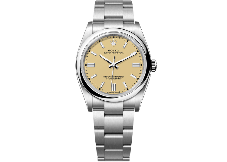 A silver Rolex Oyster Perpetual wristwatch with a beige dial, silver hour markers, and a metal link bracelet is shown against a white background—an elegant choice for watches enthusiasts attending Monterey Car Week.