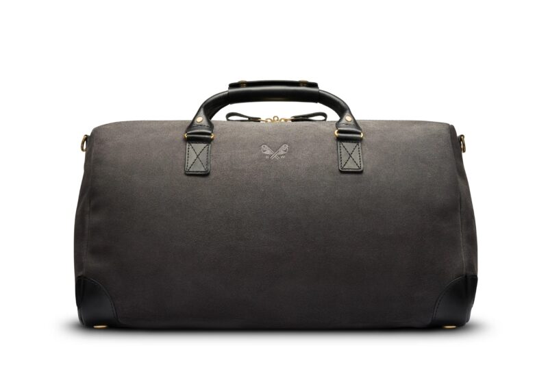 A black leather duffel bag with two handles, gold hardware, and a small butterfly logo centered below the handles, pictured against a white background—a perfect style upgrade for those seeking luxury accessories.