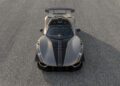 Overhead view of a Hennessey Venom F5 sports car with black accents, 031HP, manual transmission, and a large rear spoiler parked on an asphalt surface.