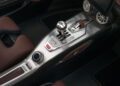 Close-up of a luxury car’s center console featuring a gated manual gear shifter, leather accents, control knobs, and air vents—evoking the refinement found in icons like the Hennessey Venom F5 and its 031HP powerhouse.