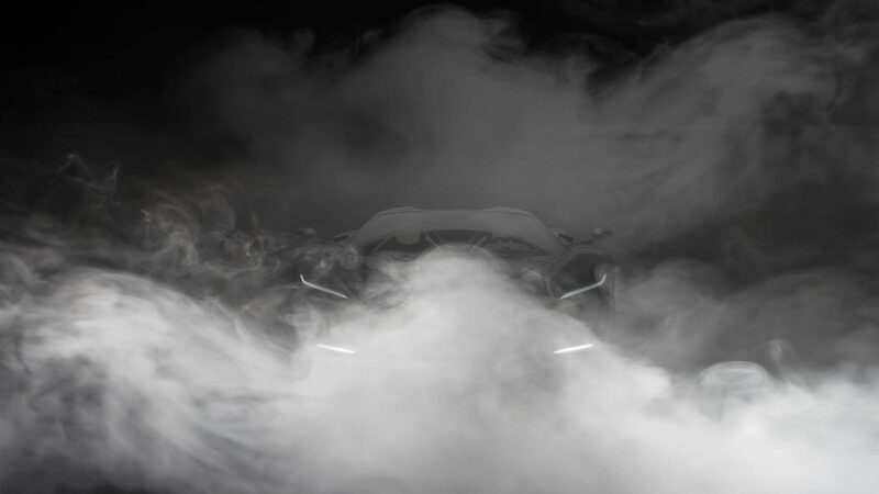 A Pininfarina AI-engineered hypercar is partially obscured by thick clouds of white smoke, its headlights faintly visible through the haze.
