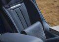 Close-up of a modern Range Rover SV Asilomar’s blue leather front seat, featuring detailed stitching and a visible armrest, with an outdoor landscape blurred in the background during Monterey Car Week.
