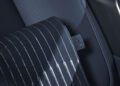 Close-up of a Range Rover SV car seat with black perforated leather upholstery and white contrast stitching, showing a fabric tag with a seatbelt icon—captured during Monterey Car Week near Asilomar.