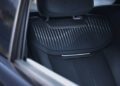 Close-up view of a black car seat and headrest with vertical stitching, seen through an open car window—inside a one-off Range Rover at Monterey Car Week.