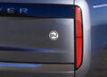 Close-up of the rear end of a blue Range Rover SV, showing the "SV" badge and part of the taillight—captured during Monterey Car Week near Asilomar.