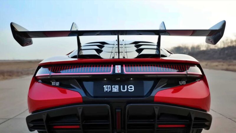 A rear view of a red sports car with a large rear wing, black accents, and a license plate displaying "U9" and Chinese characters—BYD’s YangWang U9 Track Edition just hit 472 km/h, setting a new EV top-speed record.