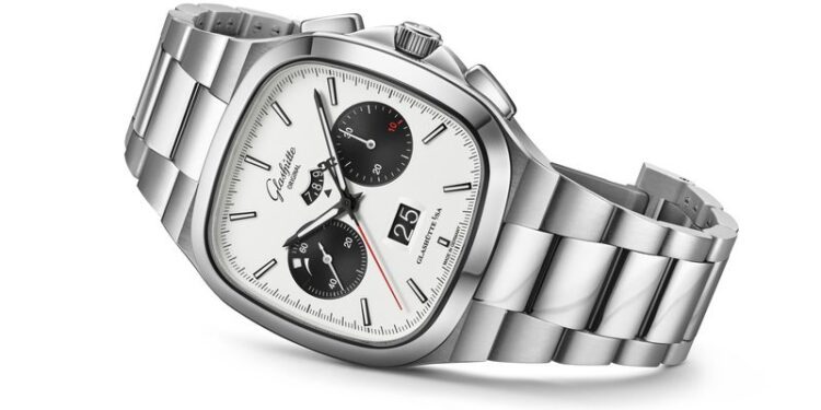 A North American-exclusive Glashütte Original Seventies X Chronograph, this stainless steel wristwatch features a white face, two black subdials, date display, and a metal link bracelet, shown at an angle.