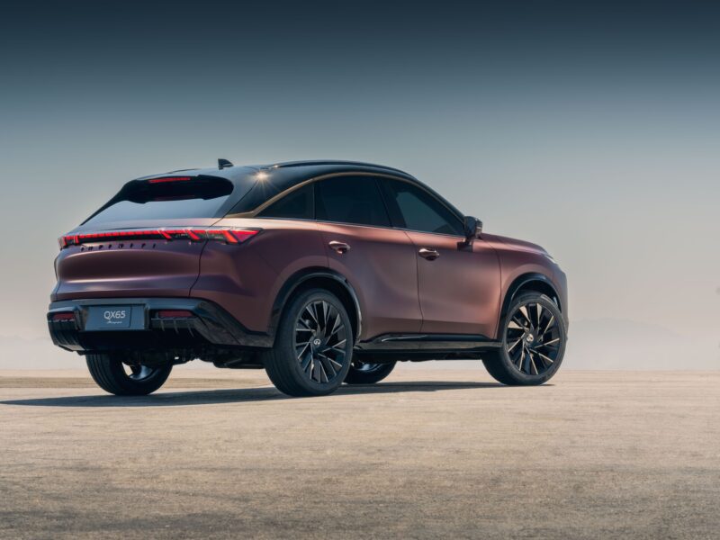 A matte maroon Infiniti QX55 SUV is parked on a flat, open surface with a clear sky in the background, channeling the bold style seen at Infiniti’s 2025 Monterey Showcase: QX80 and QX65 SUV Concepts Take Center Stage.