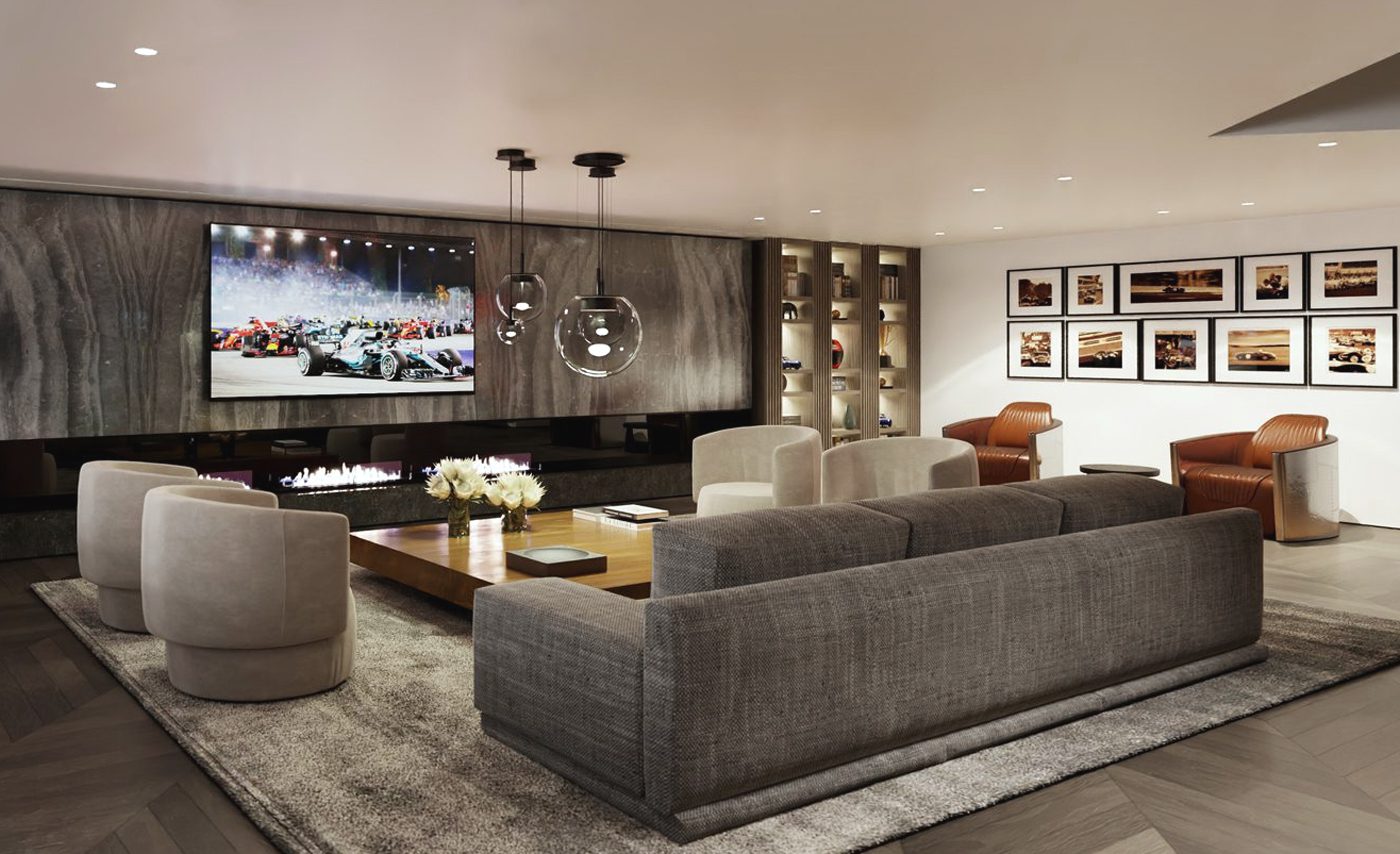 Modern living room with gray sofas, beige chairs, a wooden coffee table, wall-mounted TV, state-of-the-art storage solutions, built-in fireplace, and framed photos on the wall.
