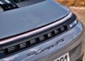 Close-up of the rear badge and tail lights of a silver Porsche 911 Carrera GTS, as seen in our review: 2025 Porsche 911 Carrera GTS T-Hybrid electrifies potent performance, highlighting the model name and part of the license plate.