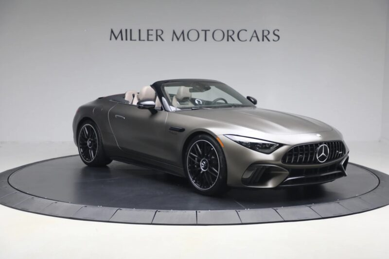 A matte gray Mercedes-Benz luxury car convertible is displayed in a showroom with "Miller Motorcars" on the wall behind it, highlighting this stunning vehicle is now for sale.