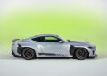 Silver 2026 Mustang RTR Spec 5 sports coupe with black accents and aerodynamic features, photographed in profile against a light green gradient background, packs more power than Ford’s GTD.