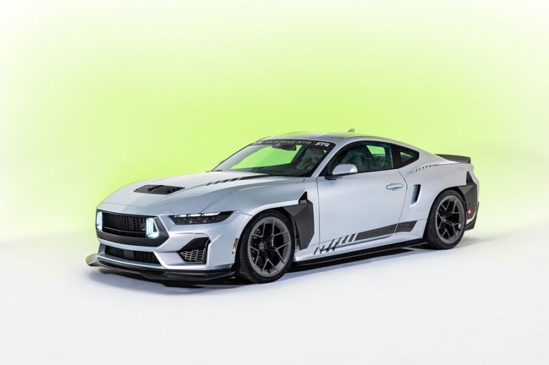 A silver custom 2026 Mustang RTR Spec 5 with black accents and aerodynamic modifications—packing more power than Ford’s GTD—is parked on a light green gradient background.