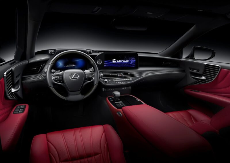 Interior of a luxury Lexus car featuring a black dashboard, digital display, and red leather seats and trim.