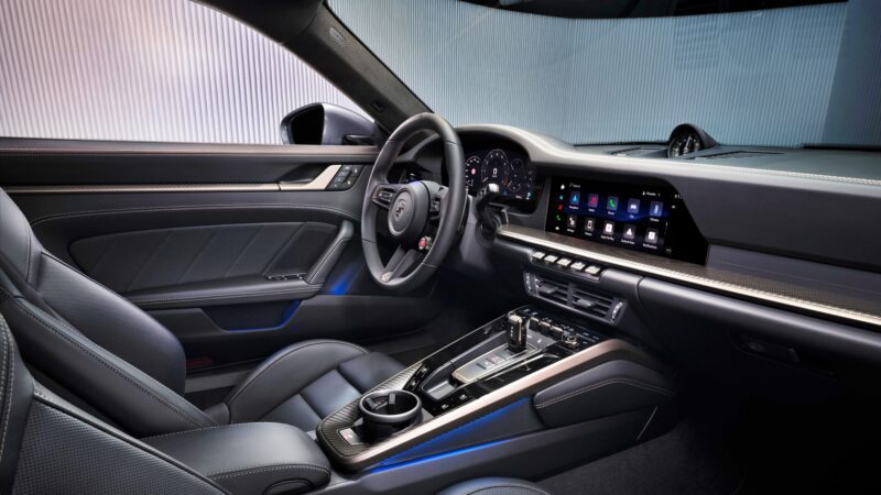Modern car interior featuring a digital dashboard, touchscreen display, leather seats, and ambient lighting—reflecting the innovation seen in the most powerful production 911: the 2026 Porsche 911 Turbo S T-Hybrid packs 701HP.