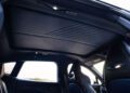 Interior view of the 2026 Aston Martin DBX S First Drive: The Best Super SUV Gets Even Better, featuring a sleek roof liner, front seats with cut-out headrests, and panoramic side windows.