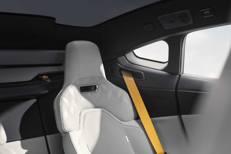 A close-up view of a modern car’s rear passenger seat with light gray upholstery and a yellow seatbelt, reflecting the minimalist interior design seen in the Polestar 5, debuting at IAA 2025 as the brand’s first true flagship EV GT.
