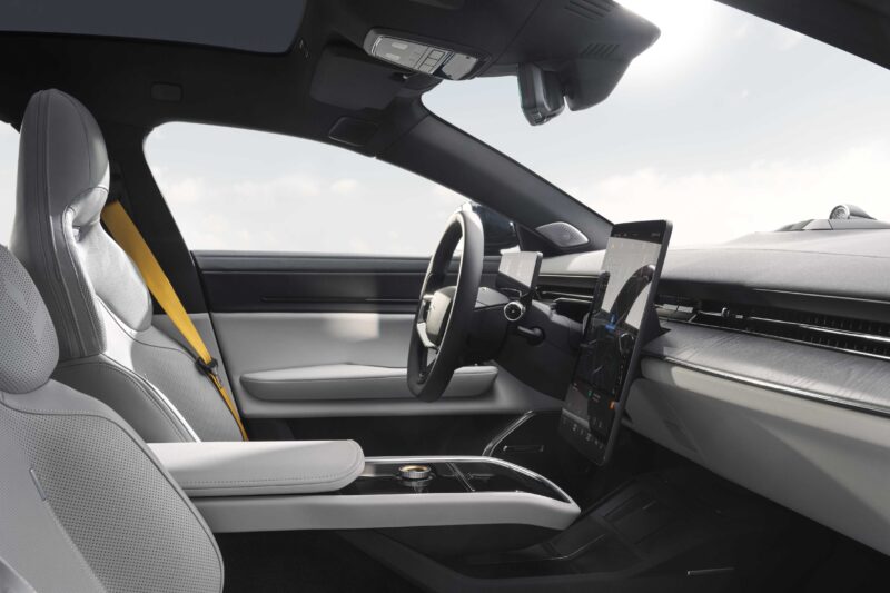 Modern car interior featuring light gray seats, a digital dashboard, a large central touchscreen display, and a yellow seatbelt—reflecting the upscale design seen in the Polestar 5 Debuts at IAA 2025 as Brand’s First True Flagship EV GT.