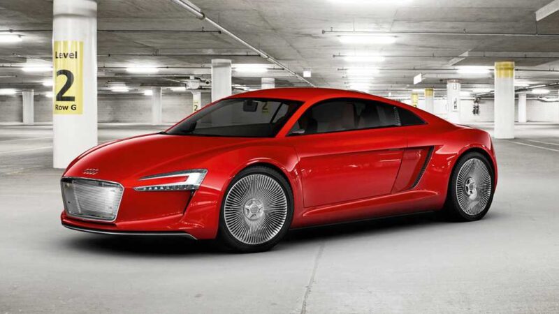 A red Audi electric car, possibly a flagship EV and Audi TT successor, is parked in an indoor garage marked with yellow Level 2 and Row G signs.