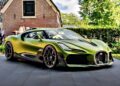 A green 1-of-1 Bugatti Brouillard is parked on a paved driveway in front of a brick house with lush greenery—making its stunning European debut at Wheels Mariënwaerdt.