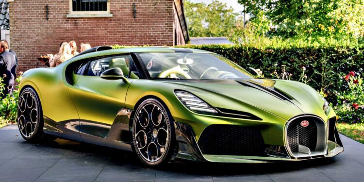 A green 1-of-1 Bugatti Brouillard is parked on a paved driveway in front of a brick house with lush greenery—making its stunning European debut at Wheels Mariënwaerdt.