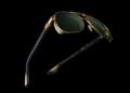 A pair of gold-framed, tourbillon-inspired aviator sunglasses with dark green lenses and black temple arms displayed on a black background—a striking addition to Bugatti’s exclusive SILMO 2025 eyewear collection.