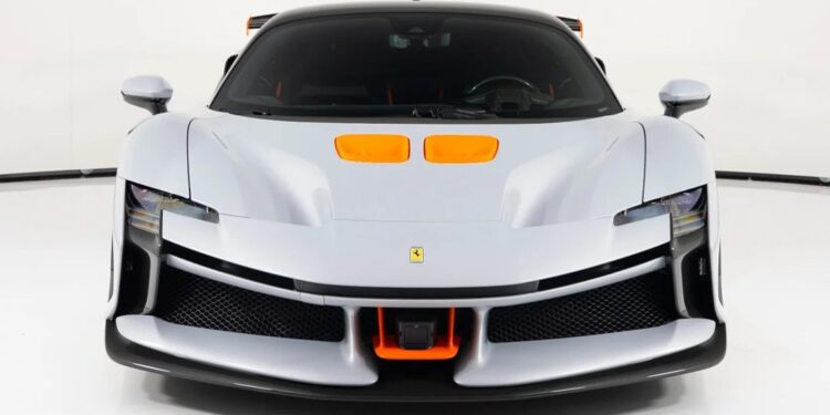 Front view of a silver Ferrari sports car with orange accents and black roof, showcasing aerodynamic features in a well-lit studio. This standout model ranks among the Most Expensive Ferraris, photographed against a white background.