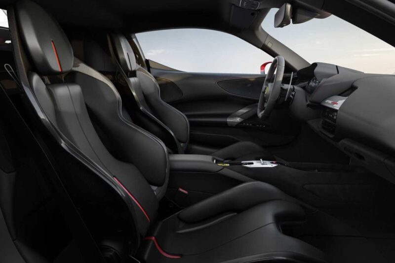 Interior view of a modern sports car with two black leather bucket seats, a central console, and a digital dashboard—echoing the refined details found in the Ferrari SF90 Stradale Vs. Ferrari 849 Testarossa comparison.