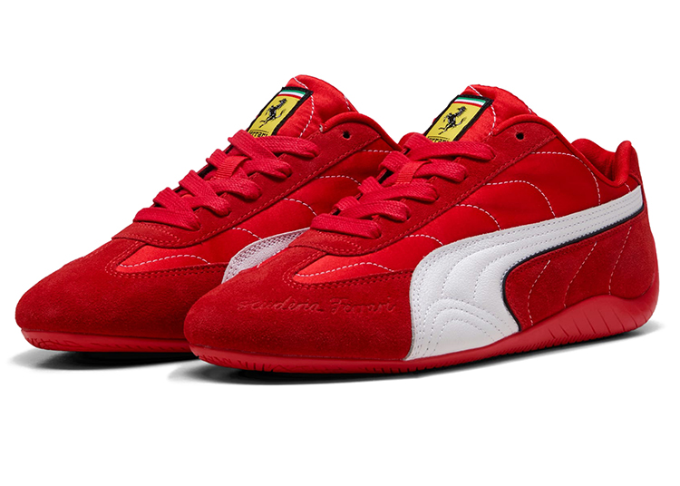 A pair of red PUMA x Ferrari athletic shoes with white side stripes, Ferrari logo on the tongue, and "Scuderia Ferrari" text on the side—part of a limited-edition collection inspired by racing legend Niki Lauda.