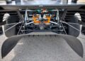 Close-up of a race car's rear view, featuring exposed suspension, rear diffuser, orange wiring, and large tires—evoking the spirit of Two Fords EVs Two Records: Lightning SuperTruck and SuperVan Conquer the Green Hell.