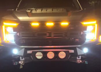 Front view of a Ford ALPHA Raptor R by SoFlo Customs at night, showcasing illuminated LED lights on the grille, headlights, and bumper.