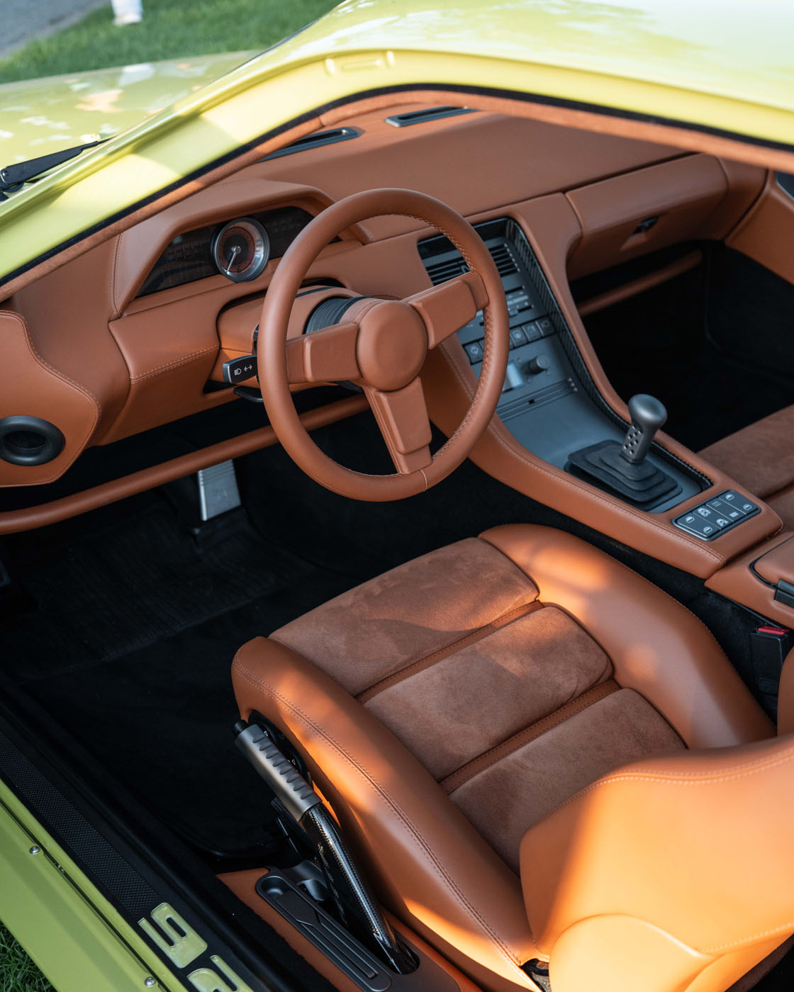Interior view of a yellow Nardone 928 sports car featuring tan leather seats, matching steering wheel, manual gear shift, and a modern dashboard—a striking production car from GH Vehicles.