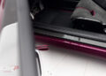 Close-up view of a car door sill with "Mansory" branding, featuring carbon fiber trim and part of the interior seat—reminiscent of the detail seen in a Gunther Werks Speedster—with a striking purple exterior.