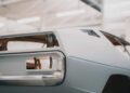 Close-up of the rear section of a vintage Lamborghini body in primer, showing the unassembled taillight area and unfinished surfaces inside a Polo Storico workshop.