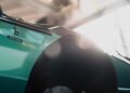 Close-up of a teal car with a "Bertone" badge on the side, partially in shadow, with sunlight streaming through a window—a stunning homage to Lamborghini’s legacy featured in Heritage Films.
