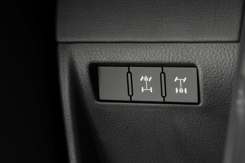 Three vehicle differential lock control buttons are shown on a black textured dashboard panel, featured in the Review: 2025 Lexus LX 700h Overtrail 4WD Is Highly Capable Moderately Practical.