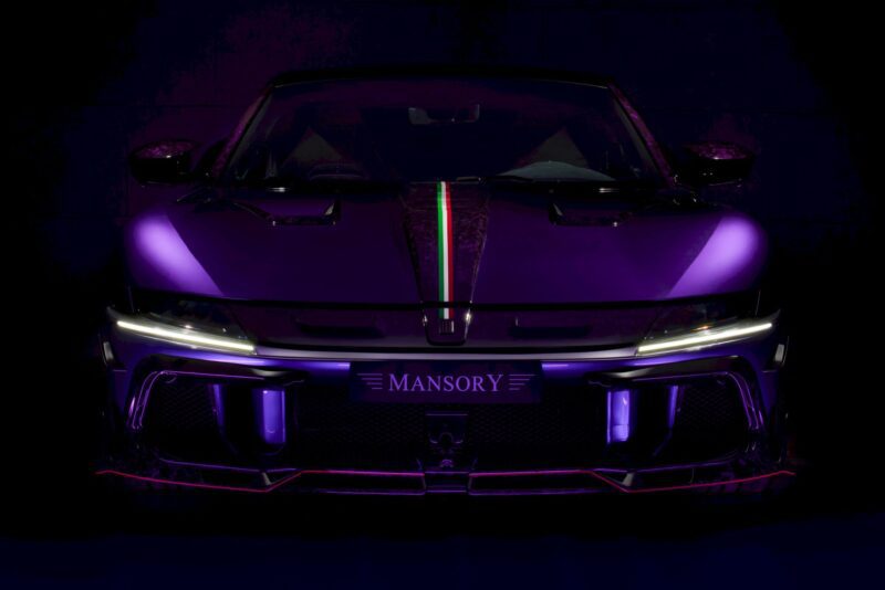 Front view of a purple Mansory sports car with LED headlights illuminated, inspired by the MANSORY Previews Ferrari 12Cilindri-based Equestre ahead of Monaco Yacht Show, set against a dark background.