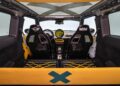 Interior view of a stripped-down Mini car featuring two racing seats, a simple dashboard, and yellow accents throughout the cabin—MINI’s Rally DNA gets a Deus makeover in these two radical JCW builds.