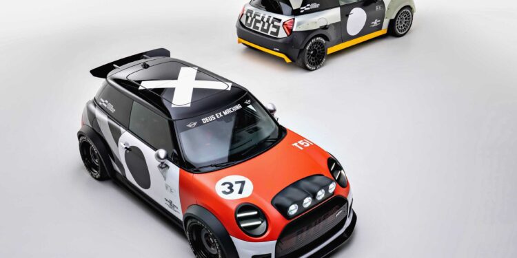 Two modified Mini Coopers, showcasing MINI’s Rally DNA with a Deus makeover, are parked on a plain white surface—one in striking orange and black, the other in bold gray and yellow.