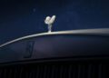 The Spirit of Ecstasy hood ornament and Rolls-Royce badge on a Cullinan grille, photographed at night beneath a starry sky that echoes the Starlight Headliner’s celestial glow.