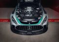 Front view of a limited edition Mercedes-AMG GT2 Edition sports car with the hood open, showcasing its engine and mechanical components in a garage pit lane.