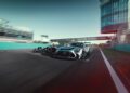 A limited edition Mercedes-AMG GT2 and a Formula 1 car race side by side on the track at Autodromo Nazionale Monza, with a track building in the background.